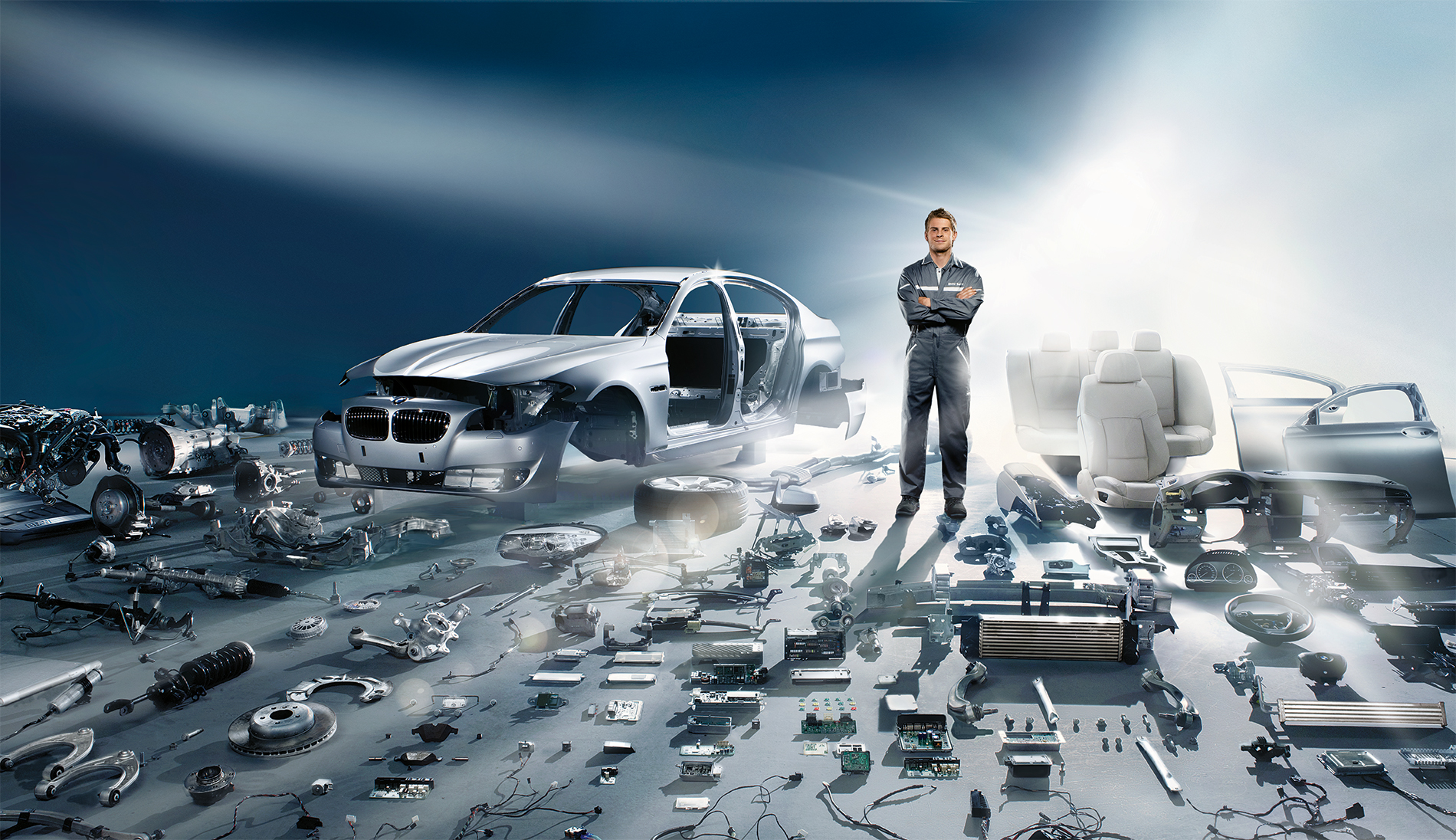 BMW Service employee standing next to BMW parts.